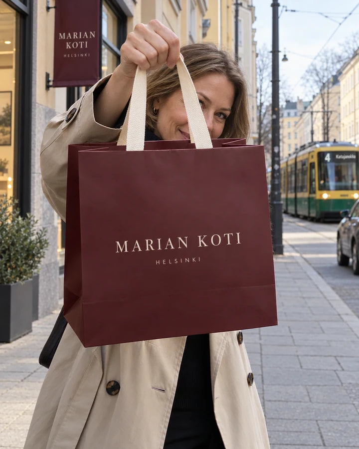 Asiakas pitelee Marian Koti Helsinki -ostoskassia